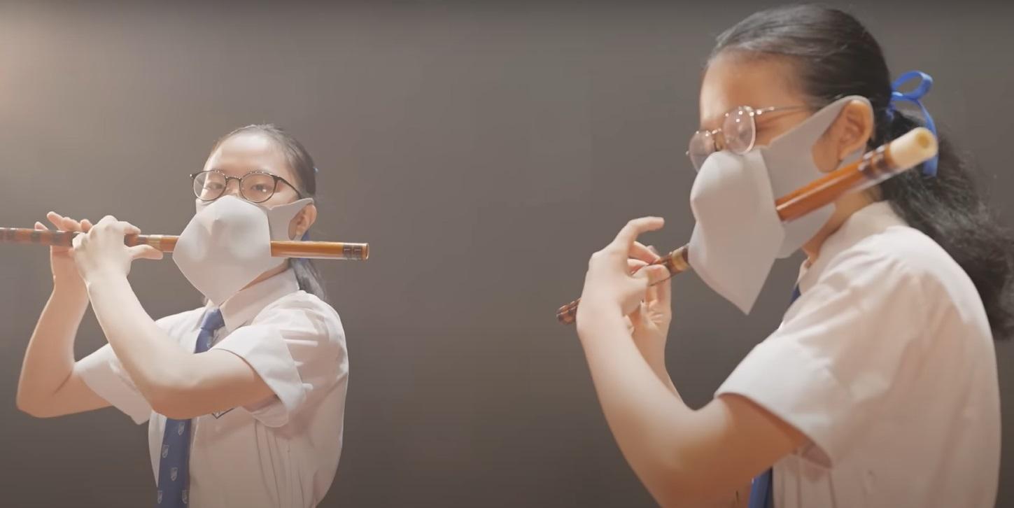 片中兩名女學生「戴罩吹笛」。(網片截圖)
