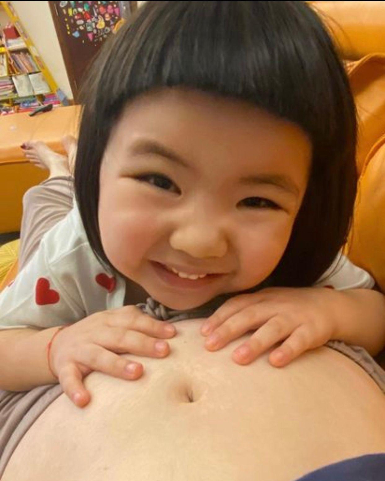 4歲Lucy將榮升家姐,趴在媽咪孕肚上拍照。