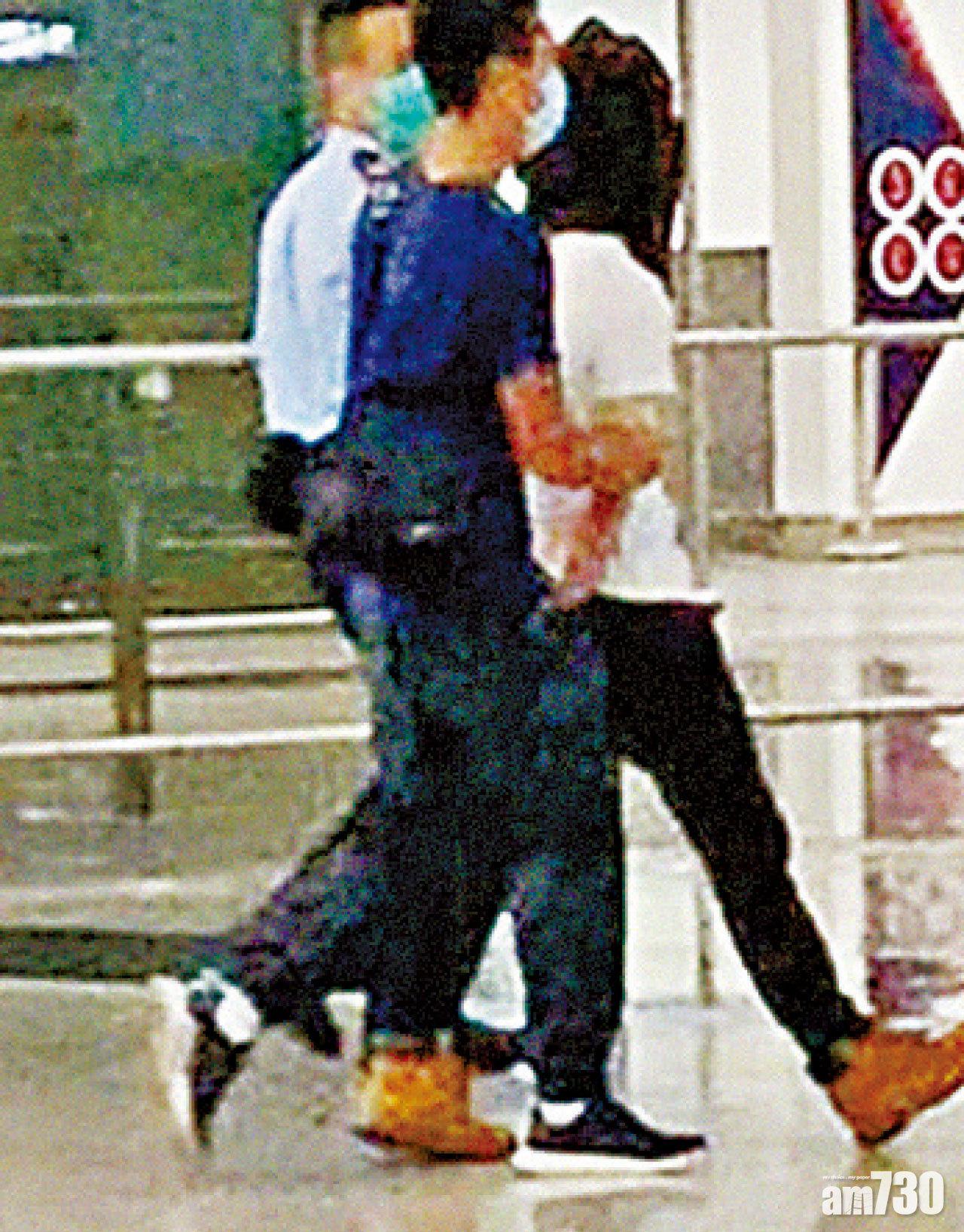 身穿白衫的疑犯黑布蒙頭被警員帶走。(網上圖片)