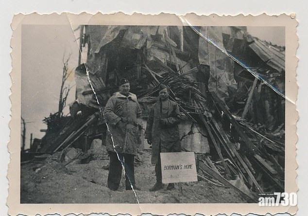 美國士兵Ragnvald Borch(右)在希特拉的別墅被轟炸後,選了希特拉坐過的廁板當戰利品。(互聯網)