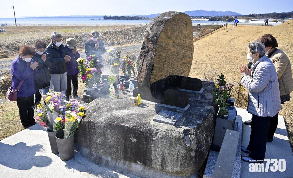 宮城縣氣仙沼市民眾在石碑前致祭。(美聯社)
