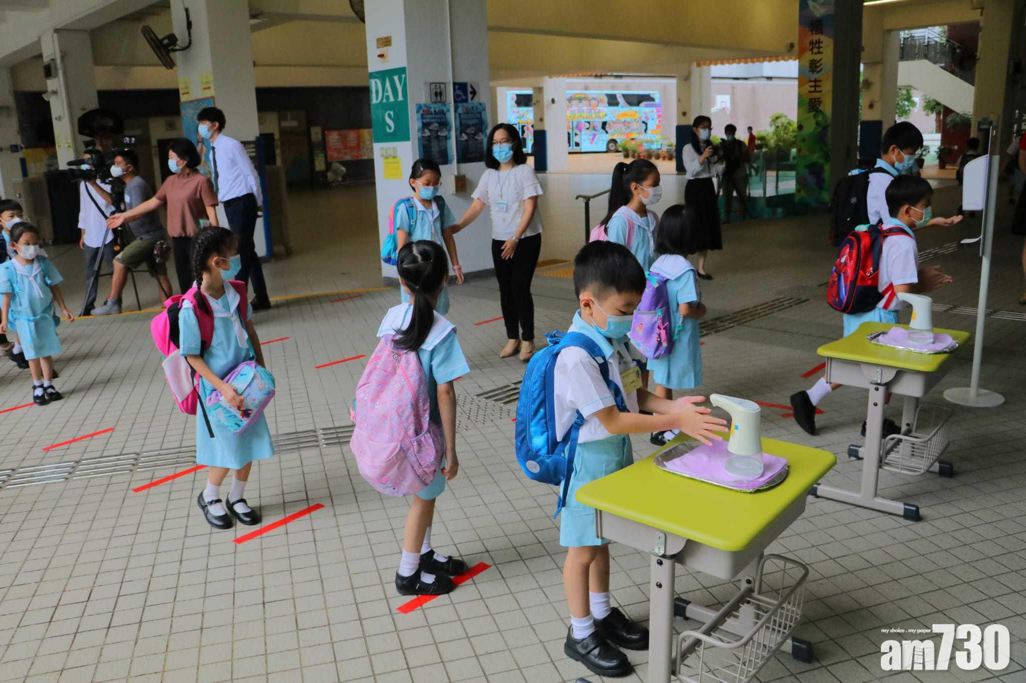 疫情下,學生進入校園之前,都要排隊量體溫及清潔雙手。(林俊源攝)
